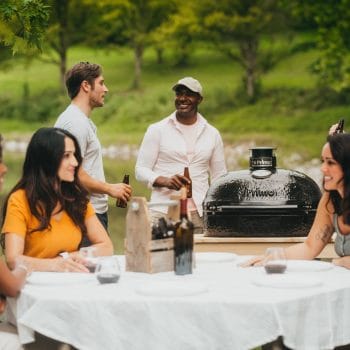 Charcoal Primo Grill between three couples enjoying the great outdoors