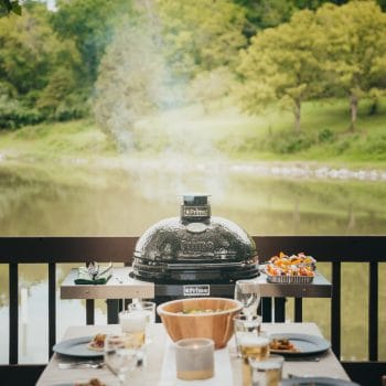 Charcoal Primo Grill in front of a table full of food