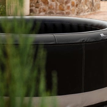 MSPA PREMIUM Super Camaro hot tub in black and white, set on a brick patio, ideal for outdoor leisure and relaxation