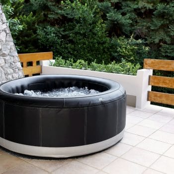 MSPA PREMIUM Super Camaro hot tub in black and white, placed on a patio, offering a relaxing outdoor experience.