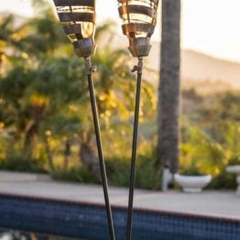 The Outdoor Plus Spiral Fire Torch is a handcrafted lighting fixture made in the USA, designed to serve as both functional art and a premium flame feature for patios, pool areas, or landscapes. Constructed from high-grade 304 stainless steel, it is built to withstand extreme temperatures and natural elements while resisting rust and corrosion. This modern torch operates at a maximum heat output of 20,000 BTU/hr and is compatible with either natural gas or liquid propane. It utilizes a simple match-lit ignition system and is available with two base options: the "Original TOP" base, which features a needle valve for precise flame adjustment and fits standard 2.5-inch posts, and the "TOP-LITE" base, designed for quick installation onto any 0.5-inch gas pipe.